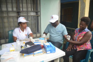 Labouratory scientist taking blood sample from a patient