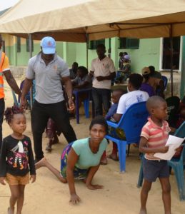 Physically challenged mother with her children being guided to receive medication
